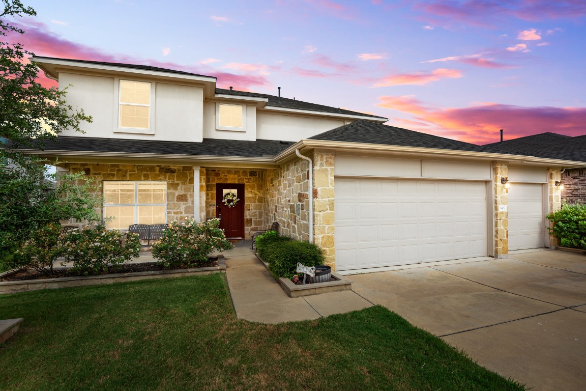 a front view of a house with a garden and plants