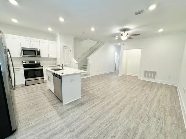 a kitchen with a refrigerator sink and cabinets