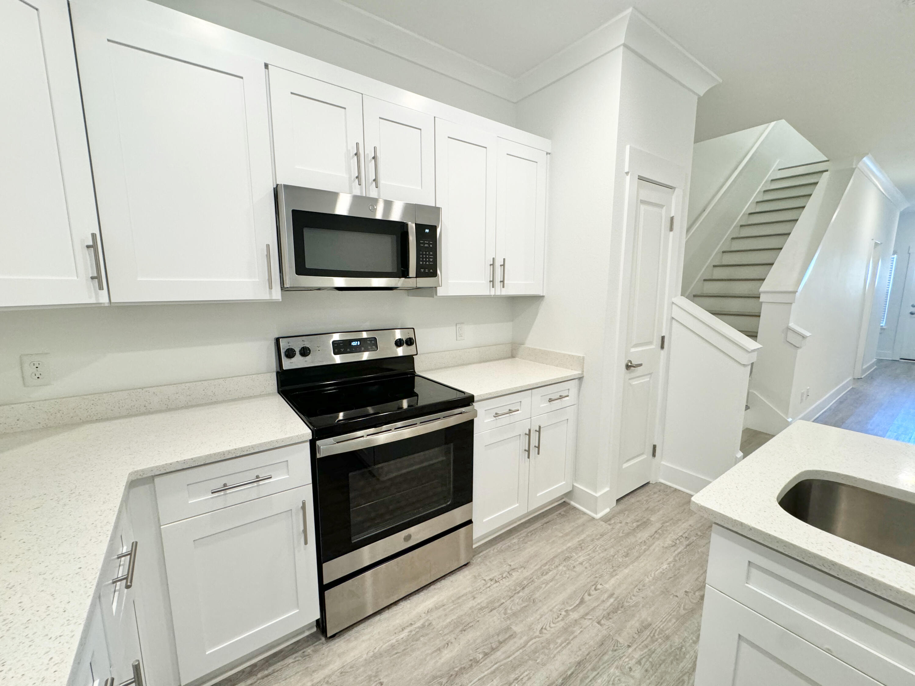 103 Date Palm Lane Freeport, FL 32439 - Photo 15 of 33 a kitchen with white cabinets and black appliances
