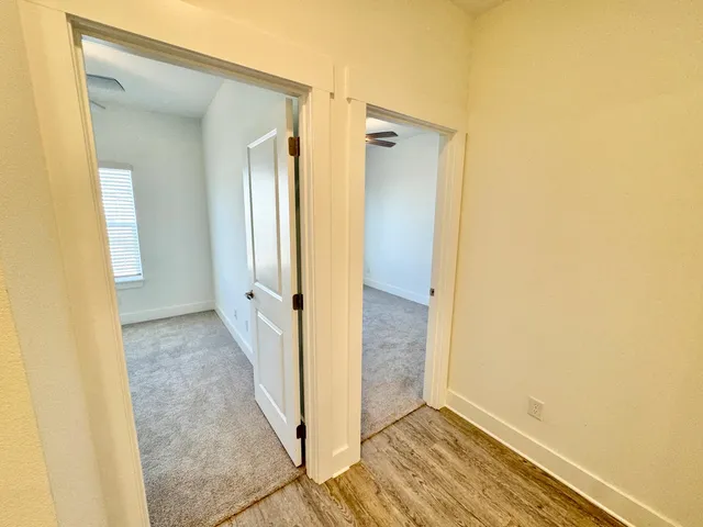 an empty room with a window and a fan