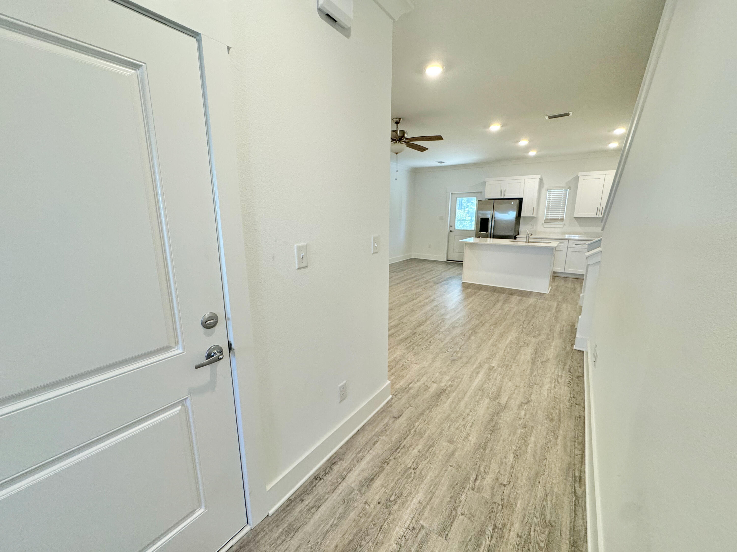 103 Date Palm Lane Freeport, FL 32439 - Photo 6 of 33 a view of a hallway with wooden floor and a bathroom