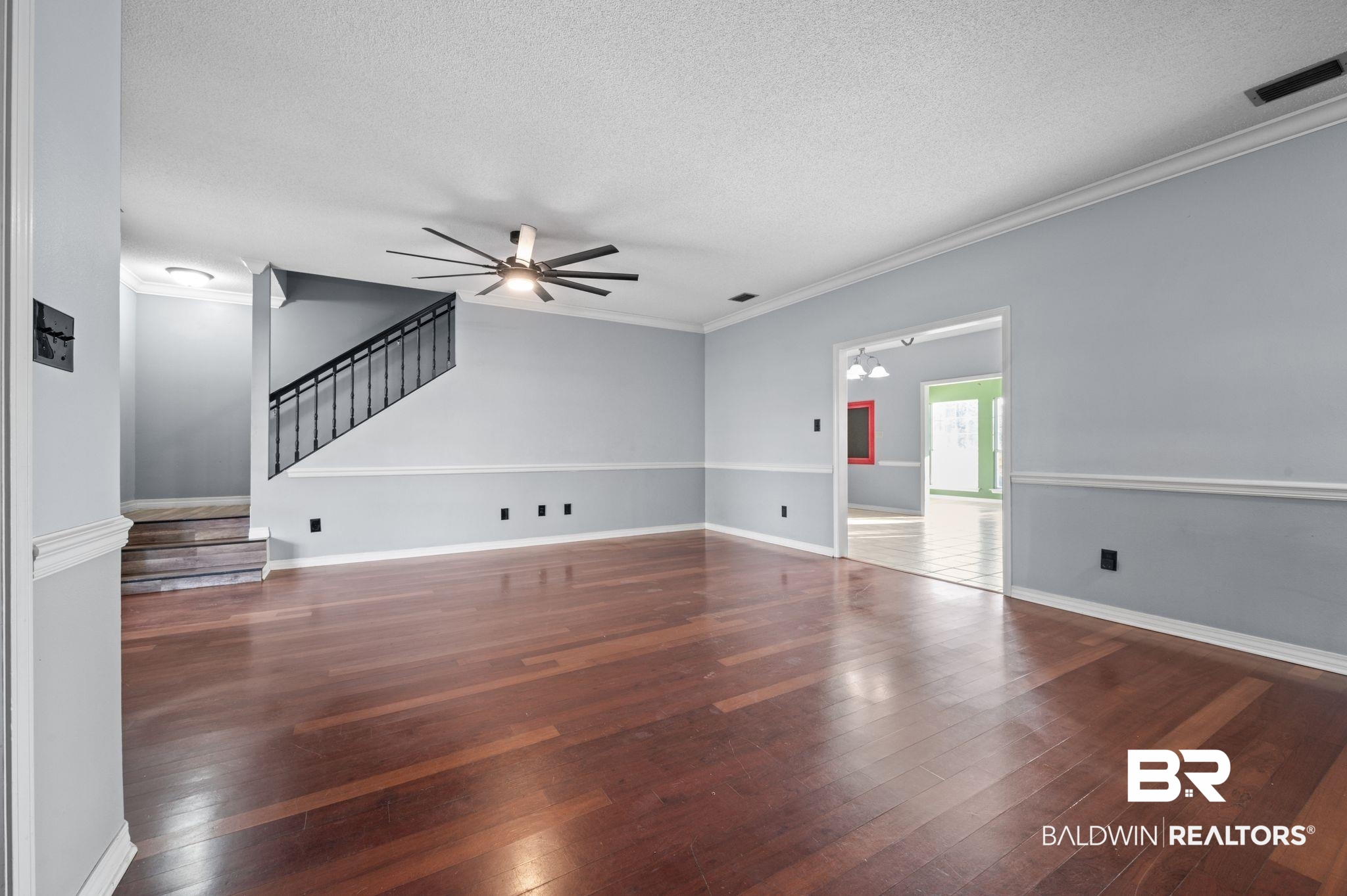 100 Orleans Way Daphne, AL 36526 - Photo 7 of 31 Unfurnished living room featuring dark hardwood / wood-style floors, ceiling fan, ornamental molding, and a textured ceiling