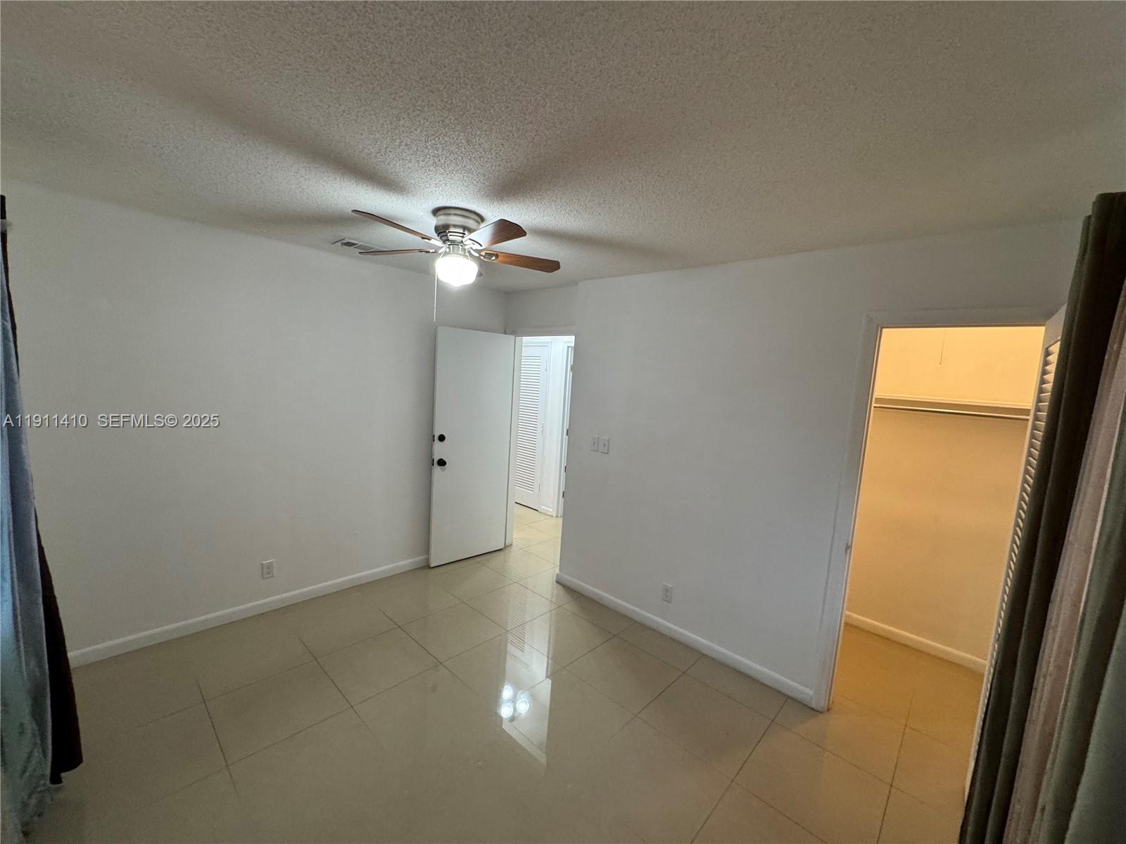 4578 Northwest 16th Avenue, Unit 4578 Tamarac, FL 33309 - Photo 12 of 24 an empty room with chandelier fan and windows