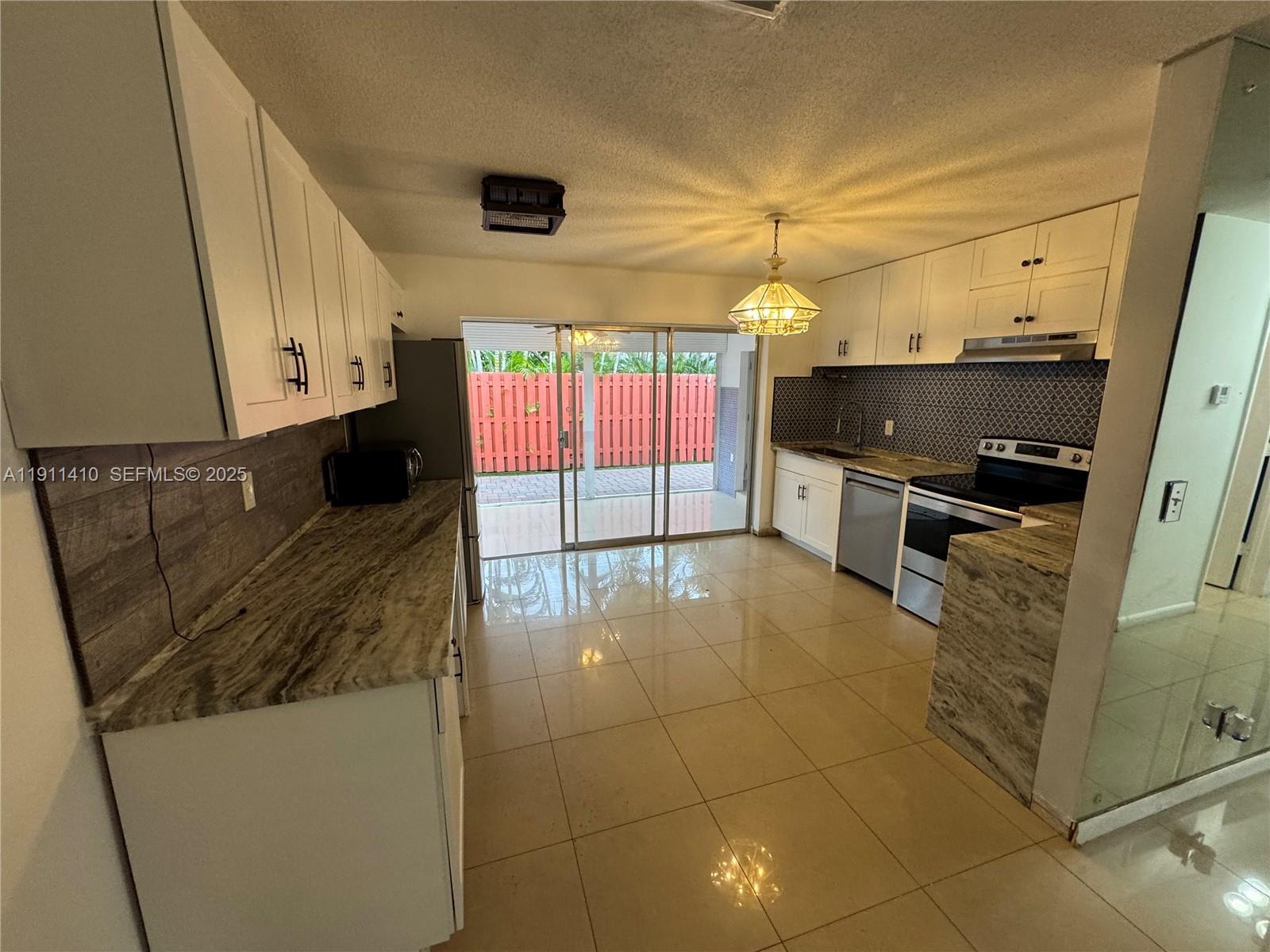 4578 Northwest 16th Avenue, Unit 4578 Tamarac, FL 33309 - Photo 5 of 24 a kitchen with stainless steel appliances a stove a sink and a microwave