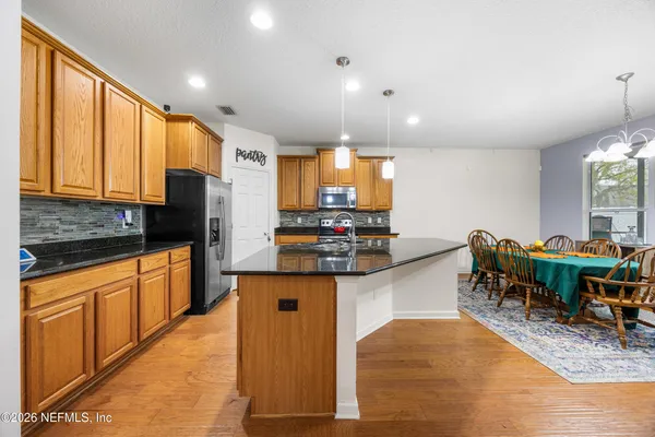 a kitchen with stainless steel appliances granite countertop sink stove top oven and cabinets