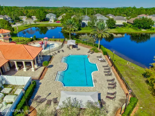 an aerial view of a house with swimming pool patio and lake view