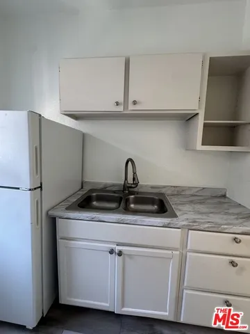 a kitchen with white cabinets and a sink