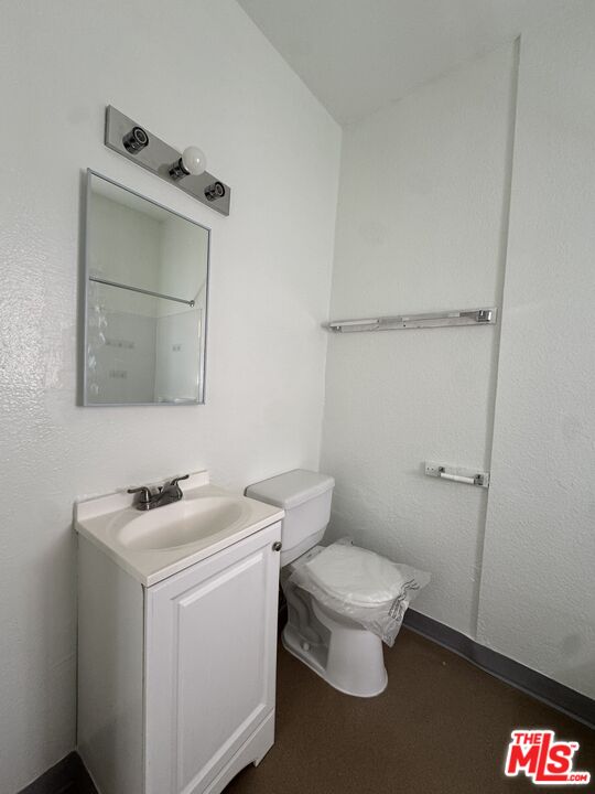 3051 Leeward Avenue, Unit 311 Los Angeles, CA 90005 - Photo 8 of 8 a bathroom with a toilet sink and mirror