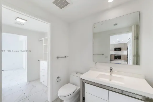 a bathroom with a sink toilet vanity and shower