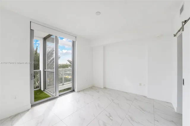 an empty room with sliding door and windows