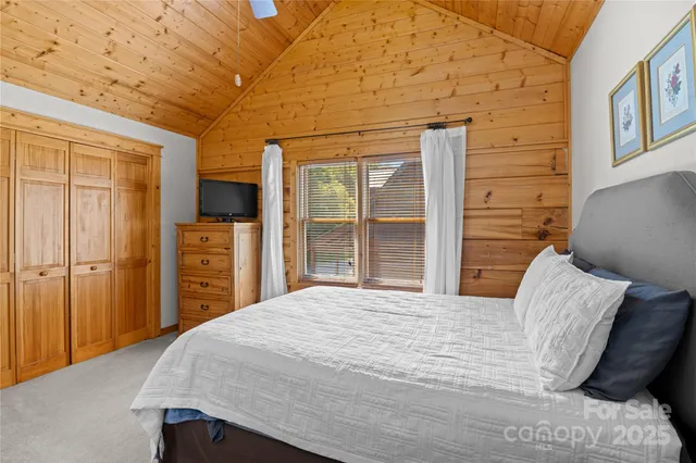 a bedroom with a bed and a flat tv screen