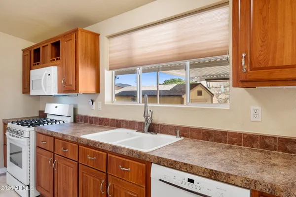a kitchen with stainless steel appliances granite countertop a sink and a window