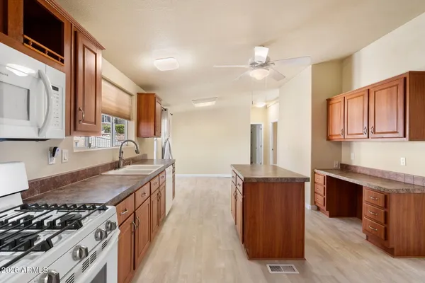 a kitchen with stainless steel appliances granite countertop a stove a sink dishwasher and a refrigerator with wooden cabinets