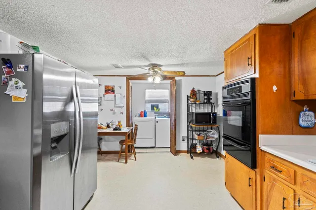 a kitchen with stainless steel appliances kitchen island granite countertop a refrigerator and a sink
