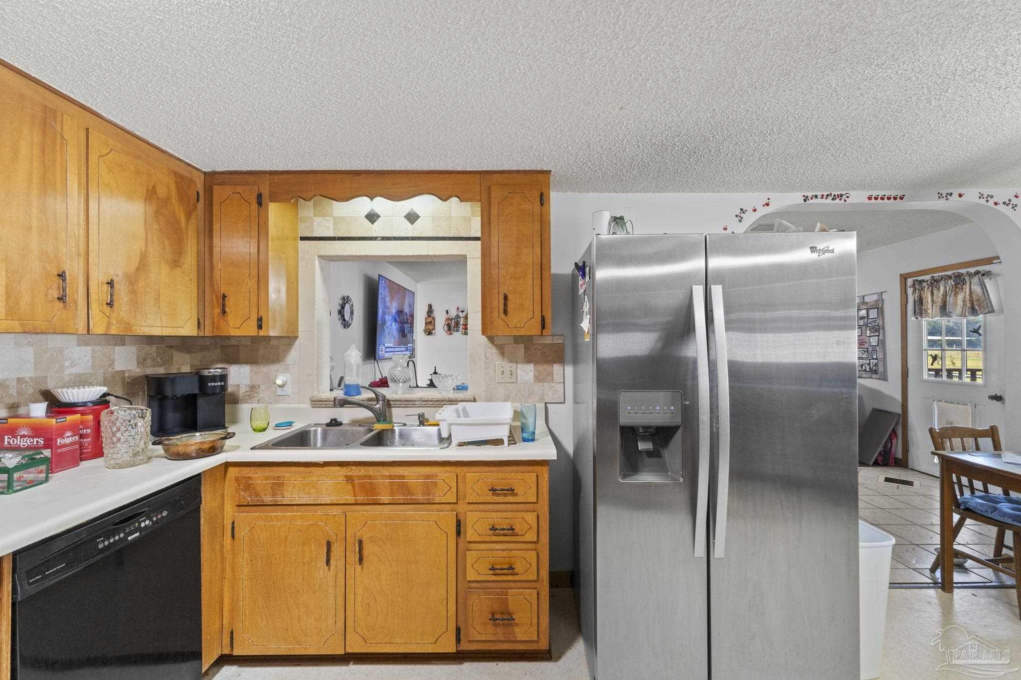 3319 Bob Tolbert Road Navarre, FL 32566 - Photo 13 of 51 a kitchen with stainless steel appliances a refrigerator sink and cabinets