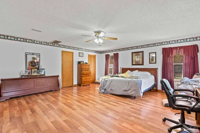 a spacious bedroom with a large bed and a chandelier