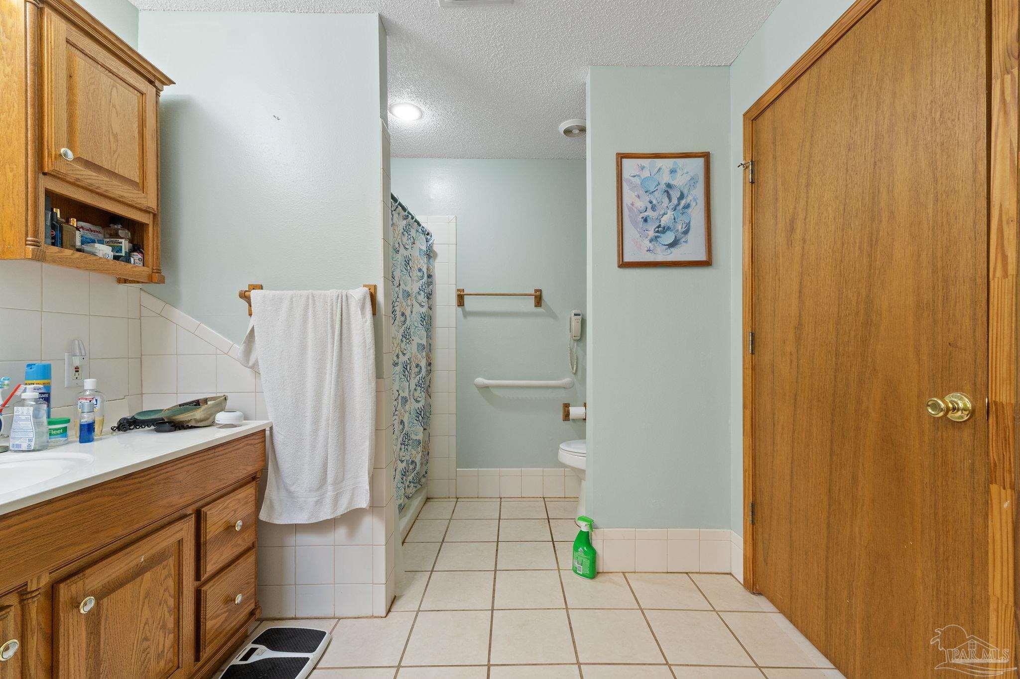3319 Bob Tolbert Road Navarre, FL 32566 - Photo 20 of 51 a bathroom with a sink a toilet and shower