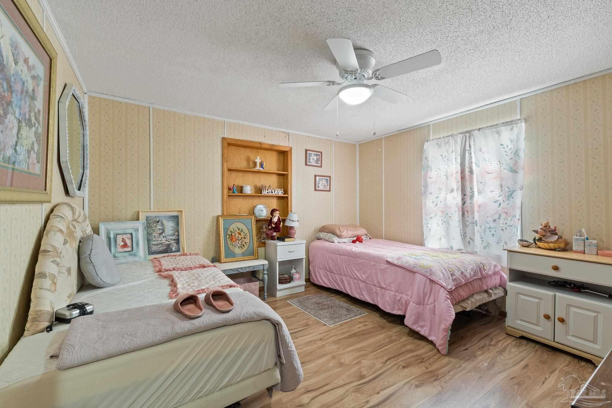 3319 Bob Tolbert Road Navarre, FL 32566 - Photo 22 of 51 a bedroom with two beds and a chandelier