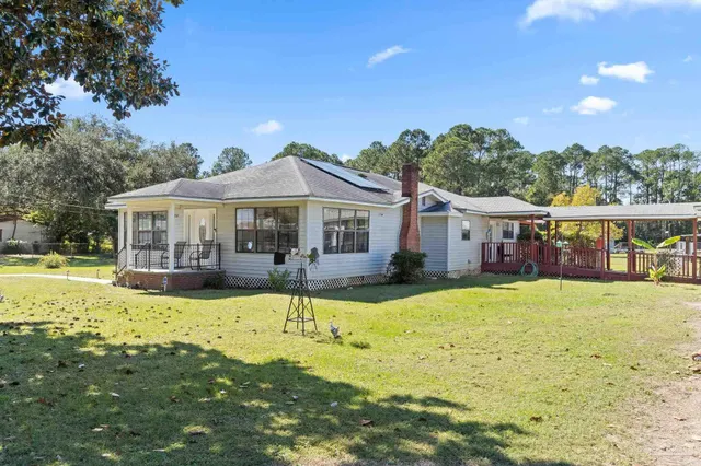 a front view of a house with swimming pool and porch with furniture
