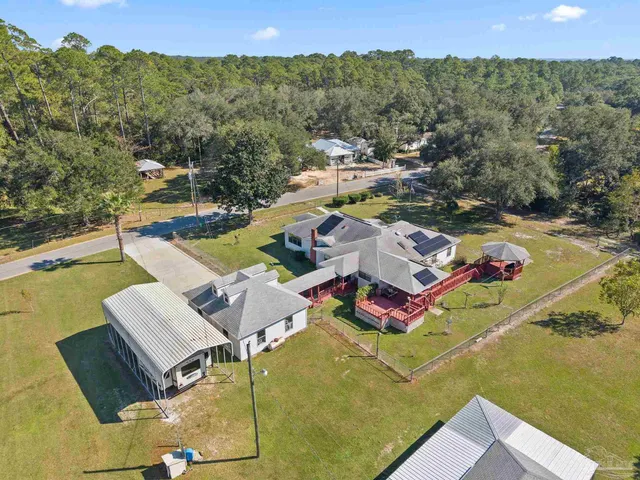 an aerial view of a house with yard swimming pool and outdoor seating