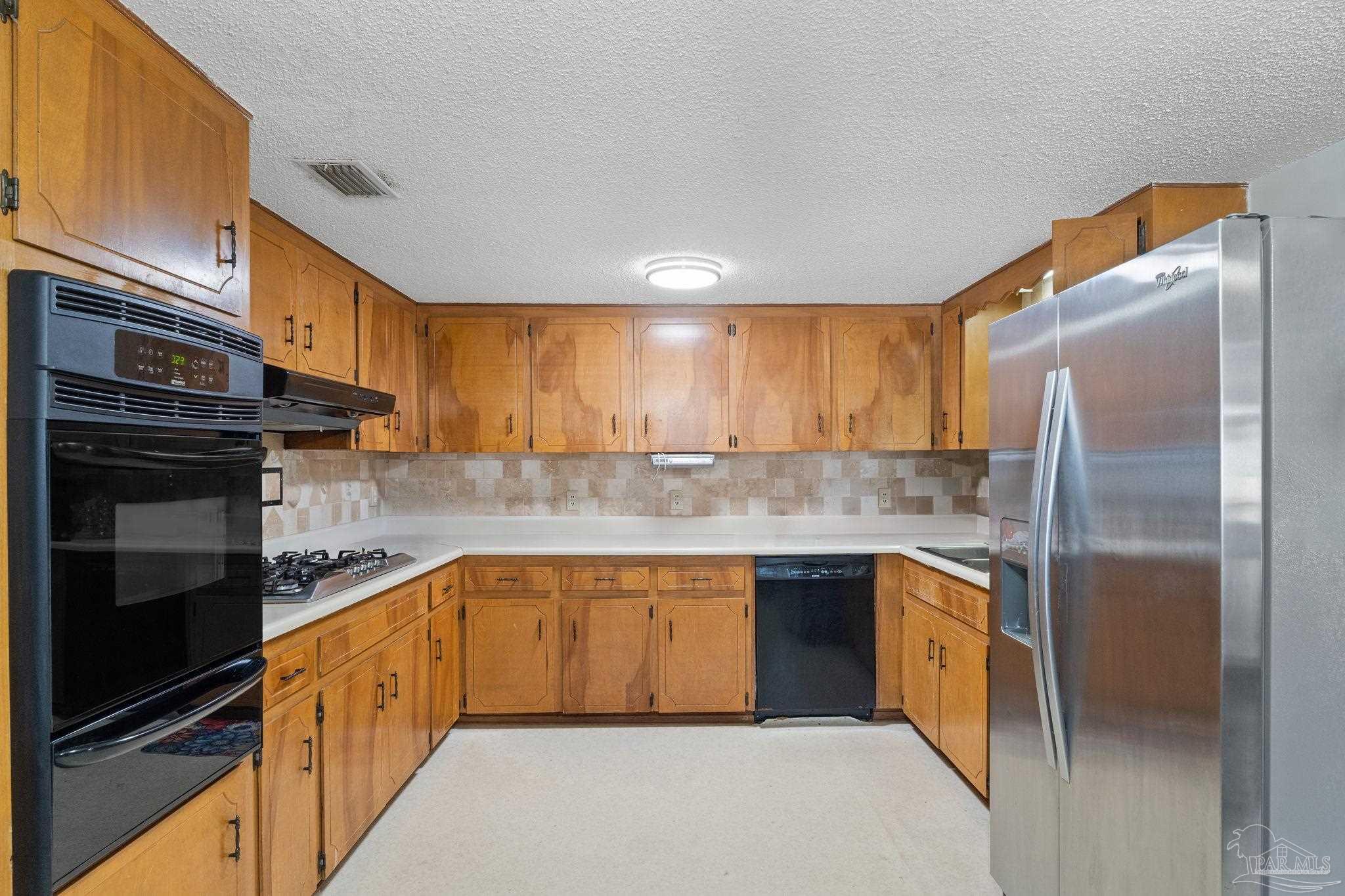 3319 Bob Tolbert Road Navarre, FL 32566 - Photo 10 of 51 a kitchen with stainless steel appliances granite countertop a refrigerator a oven a sink and dishwasher