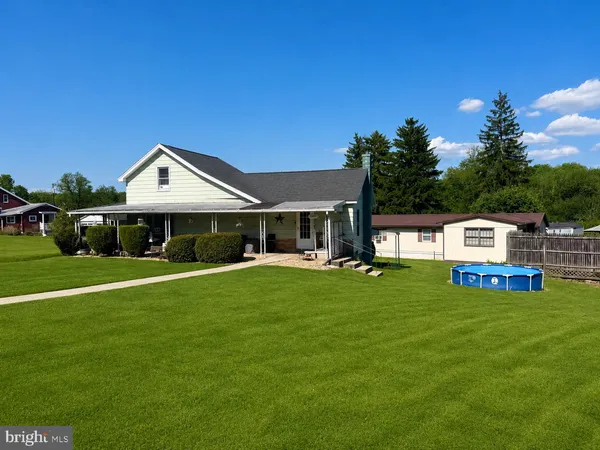 a front view of a house with a garden and trees