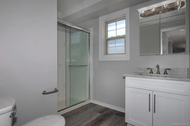 a bathroom with a granite countertop sink toilet and shower