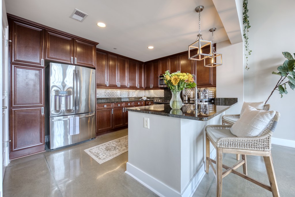 1201 Front Avenue, Unit 522 Columbus, GA 31901 - Photo 13 of 56 a kitchen with refrigerator and chairs