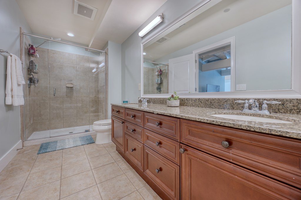 1201 Front Avenue, Unit 522 Columbus, GA 31901 - Photo 35 of 56 a spacious bathroom with a granite countertop sink a toilet a mirror and shower