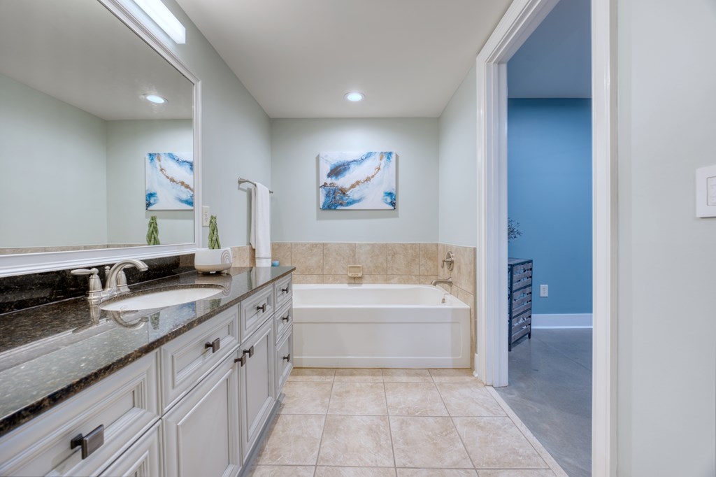 1201 Front Avenue, Unit 522 Columbus, GA 31901 - Photo 48 of 56 a spacious bathroom with a granite countertop sink a toilet and a bathtub