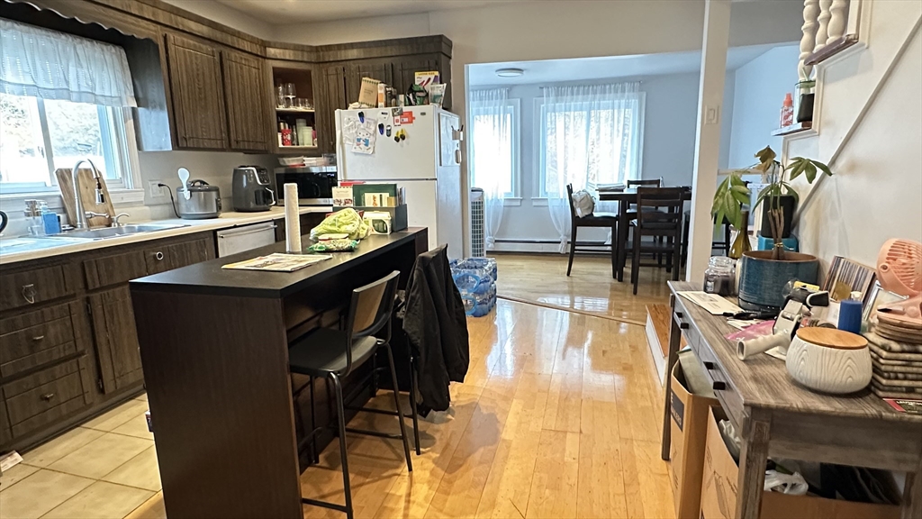 46-48 Buckley Street Quincy, MA 02169 - Photo 11 of 42 a kitchen with stainless steel appliances granite countertop a sink refrigerator and chairs