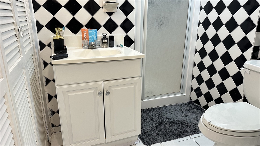 46-48 Buckley Street Quincy, MA 02169 - Photo 23 of 42 a bathroom with a sink a toilet and shower curtain