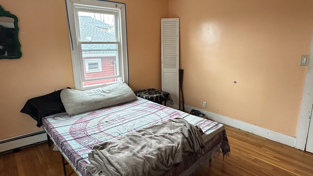 46-48 Buckley Street Quincy, MA 02169 - Photo 34 of 42 a bedroom with a bed and wooden floor
