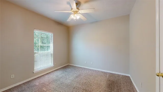 an empty room with a window and a fan