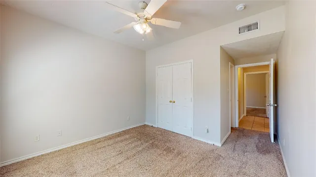 an empty room with a ceiling fan and a bathroom