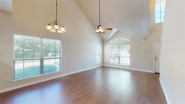 a view of a livingroom with a chandelier wooden floor and a chandelier