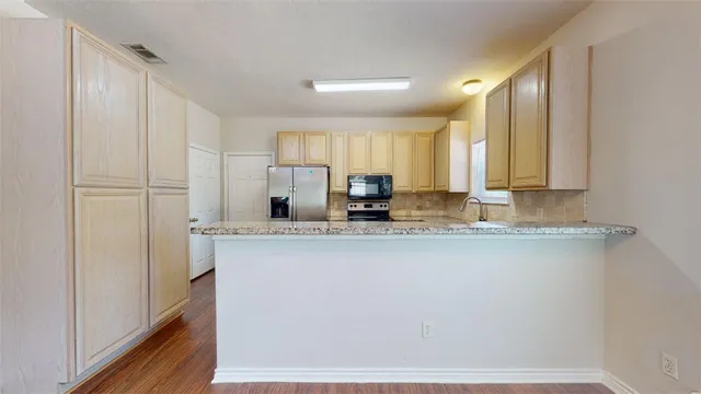 a kitchen with stainless steel appliances granite countertop a sink a stove and a refrigerator
