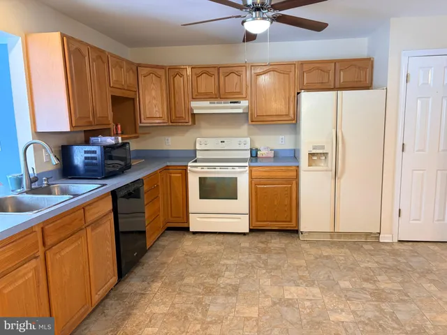 a kitchen with stainless steel appliances granite countertop a sink a stove and a refrigerator
