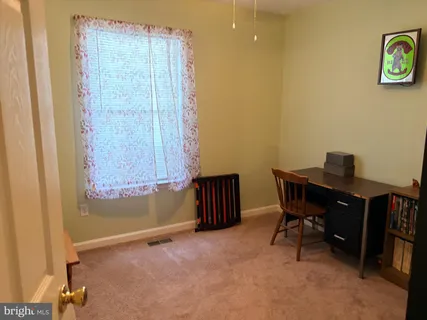 a view of a workspace with furniture and a window