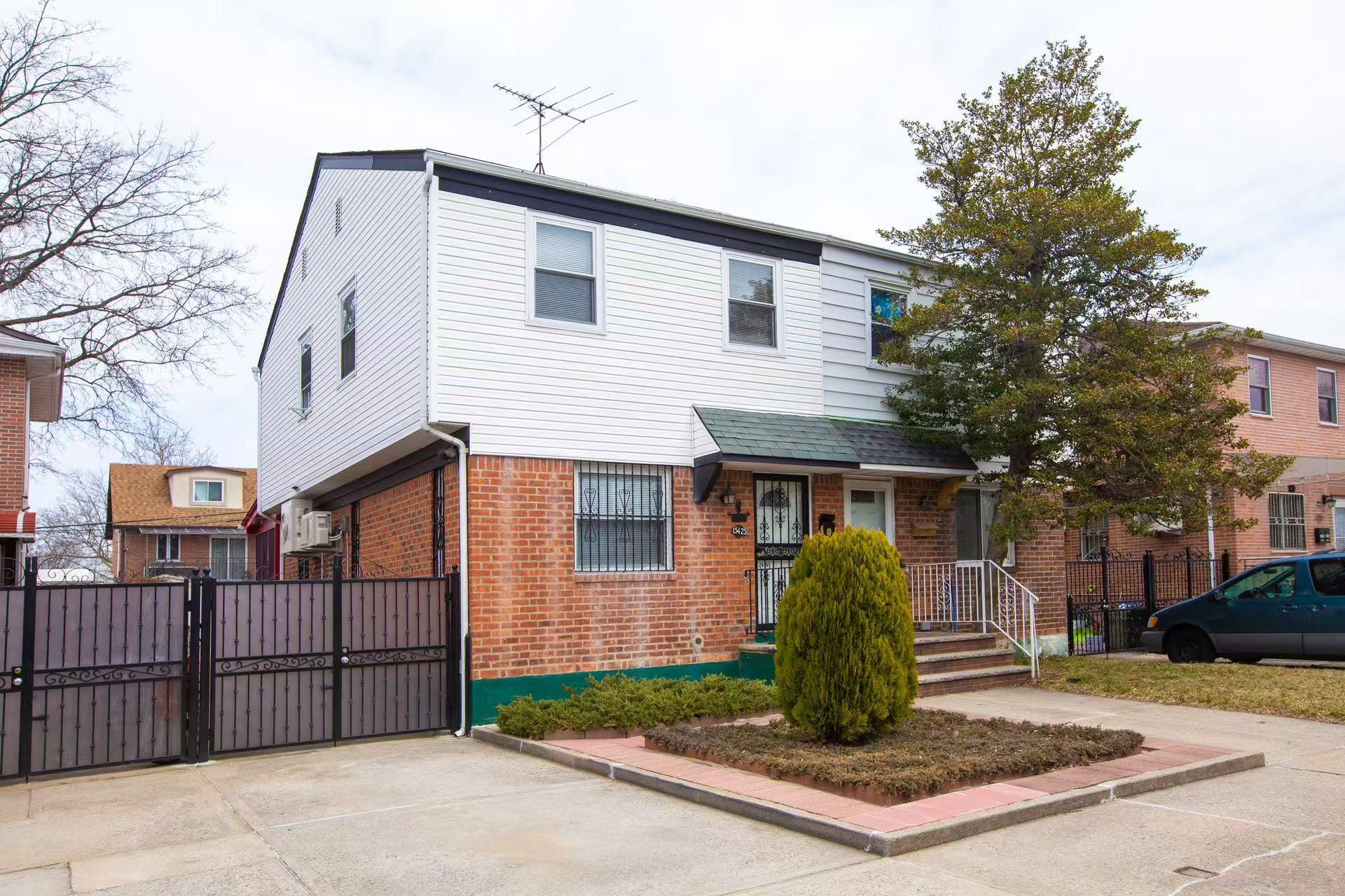 View of front of property featuring brick siding, fence, and a gate