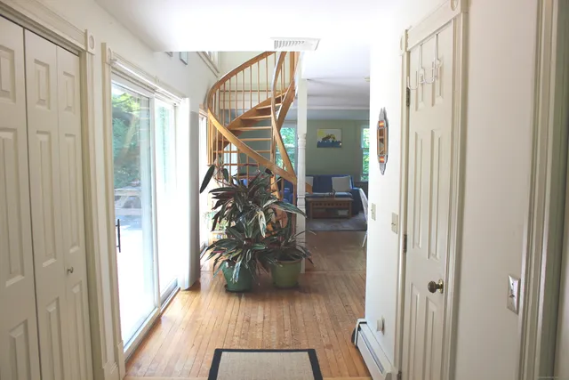 a view of entryway and hall with wooden floor