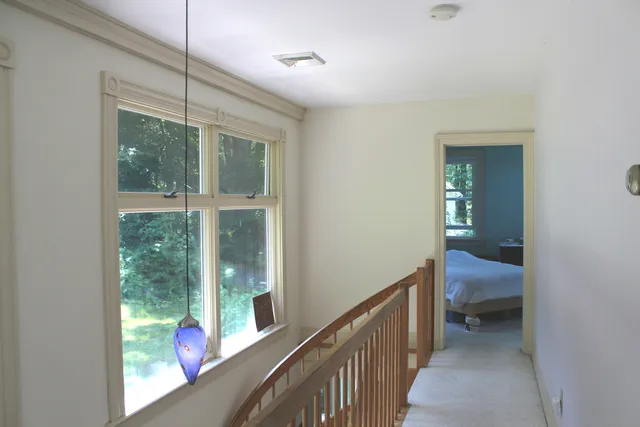 a view of a room with windows chair and front door
