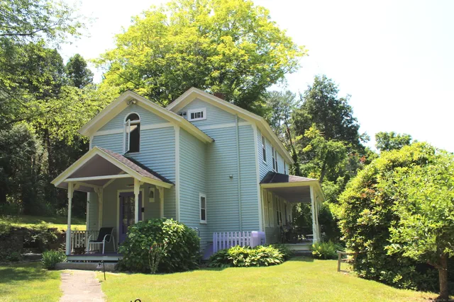 a front view of a house with yard and green space