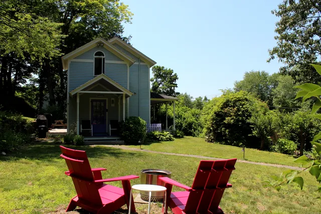 a front view of a house with swimming pool table and chairs