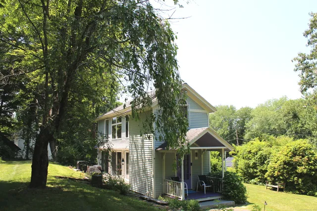 a front view of a house with yard and green space