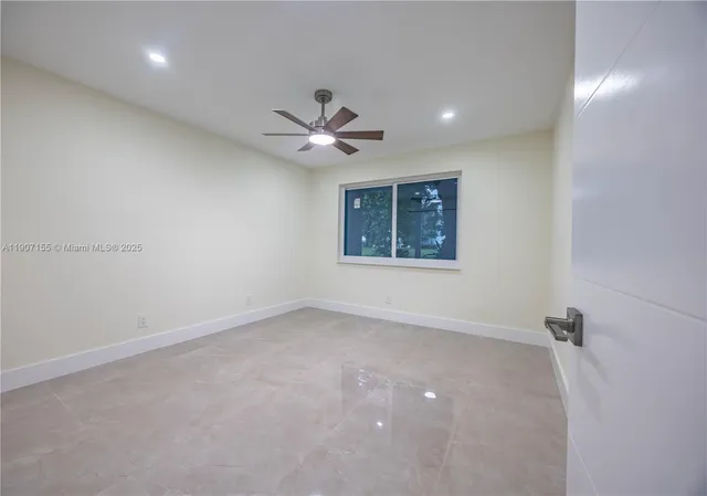 an empty room with a ceiling fan and a bathroom