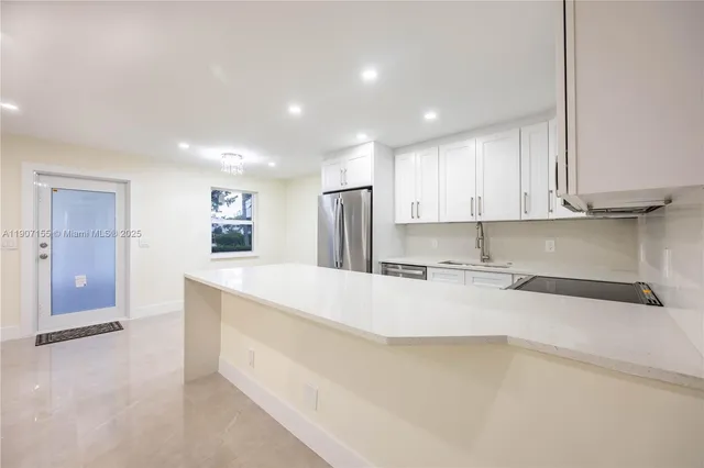 a large kitchen with kitchen island a sink stainless steel appliances and cabinets