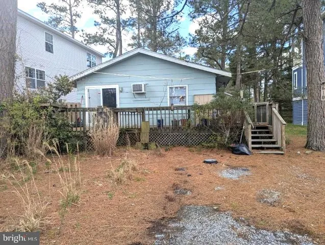 a view of a house with large trees and wooden fence