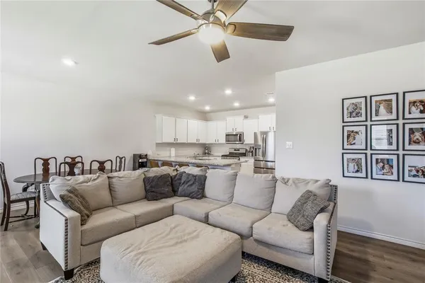 a living room with furniture kitchen view and a window
