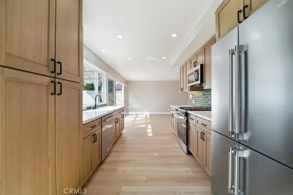 a large kitchen with stainless steel appliances granite countertop a lot of counter space and a sink